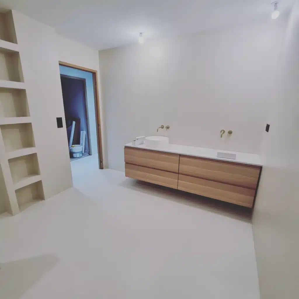 Salle de bain moderne : meuble vasque bois et robinet or Salle de bain minimaliste avec meuble vasque en bois, robinetterie laiton et étagères encastrées.